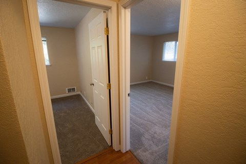 a bedroom with a white door and a carpeted floor