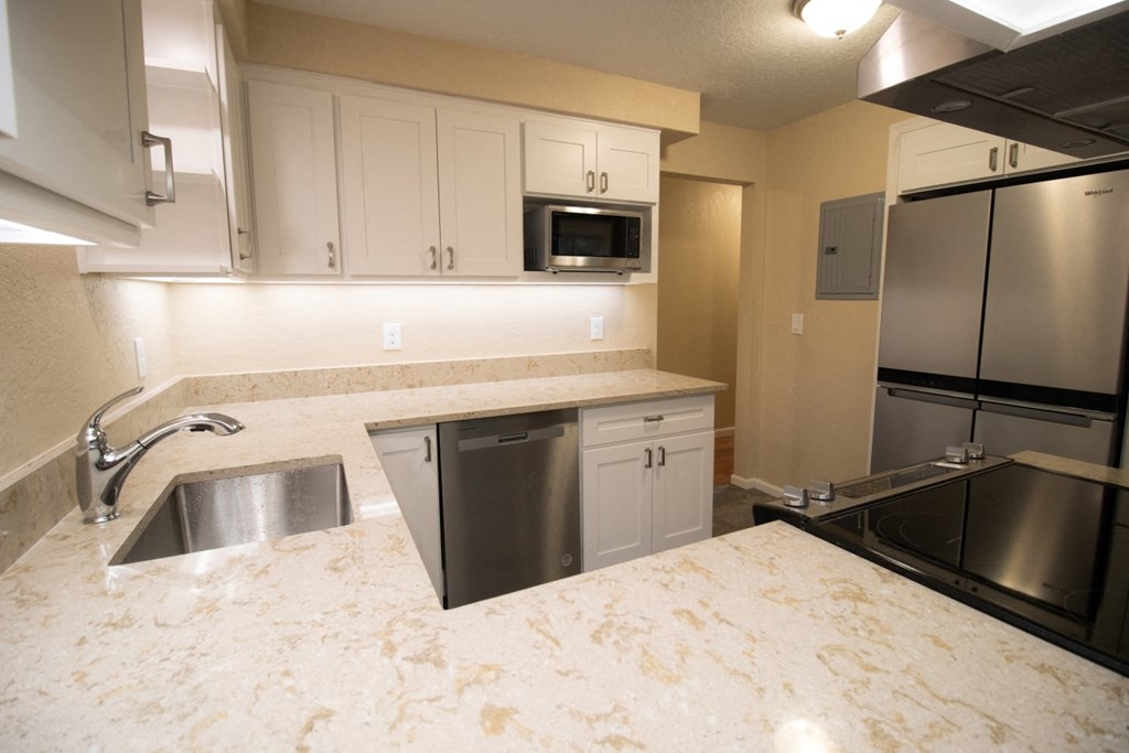 a kitchen with stainless steel appliances and white counter tops