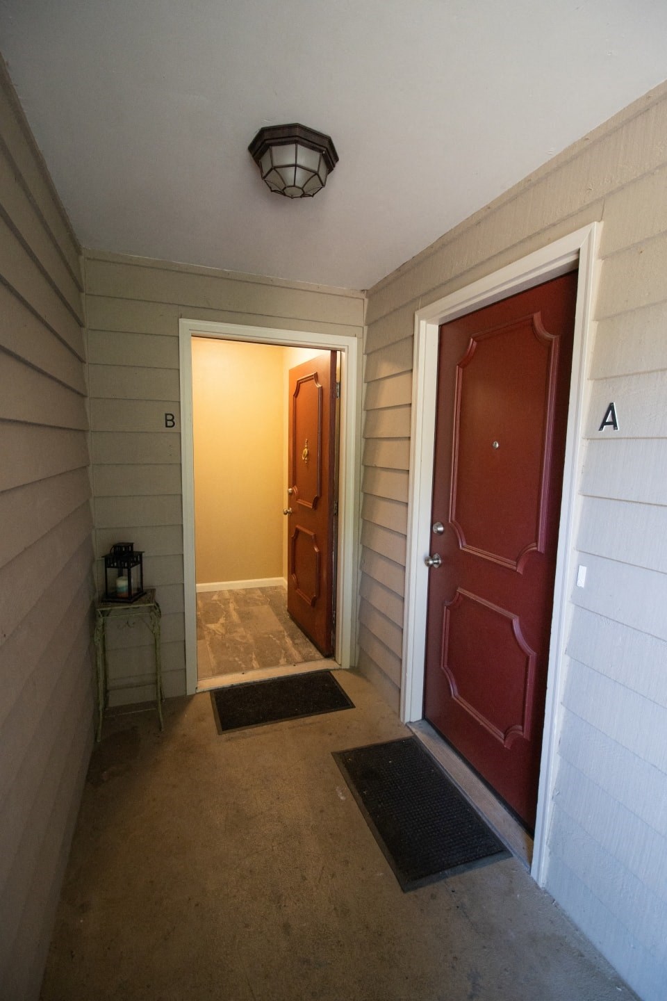 a hallway with a red door and a door way to a room with a door
