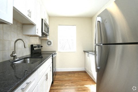 a kitchen with a stainless steel refrigerator and a sink