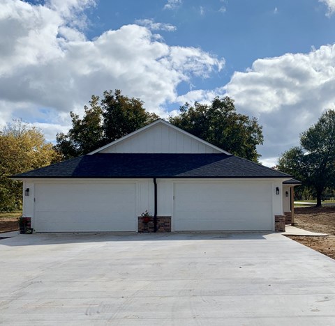 a white garage with a blue roof on a cloudy day