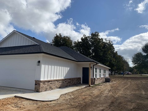 a white house with a paved driveway and a garage