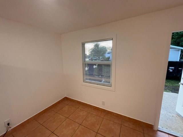 A room with a window and tiled floor.