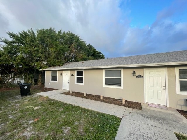 A small house with a white door and a brown roof.