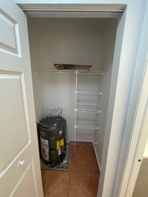 A small pantry with a water heater on the floor.