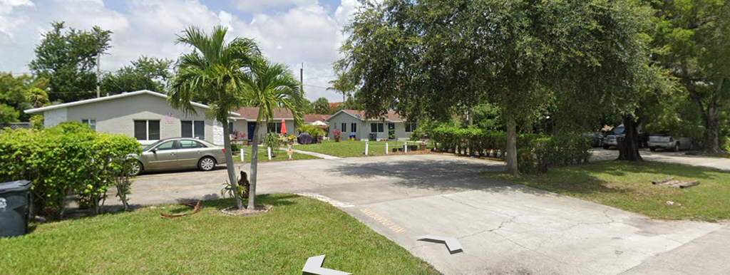 A residential area with a house, a car, and a tree.