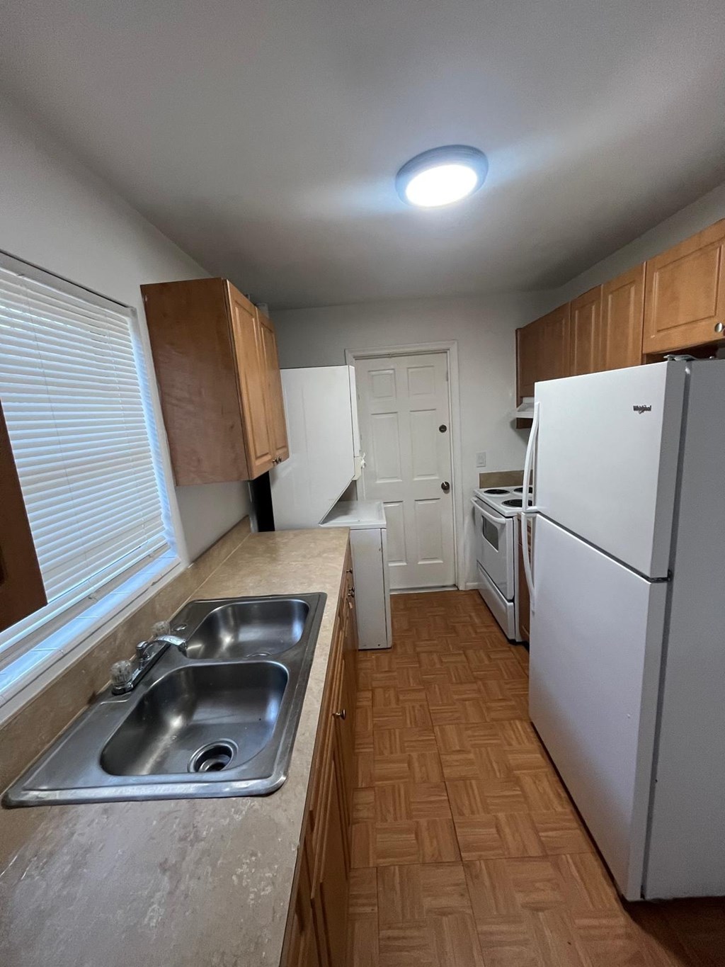A kitchen with a sink and a refrigerator.