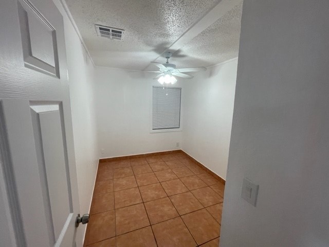 A room with a brown tile floor and a ceiling fan.