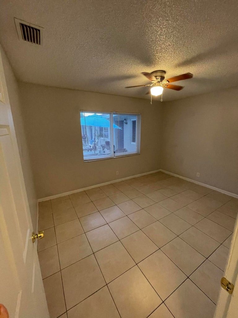 A room with a ceiling fan and a window.