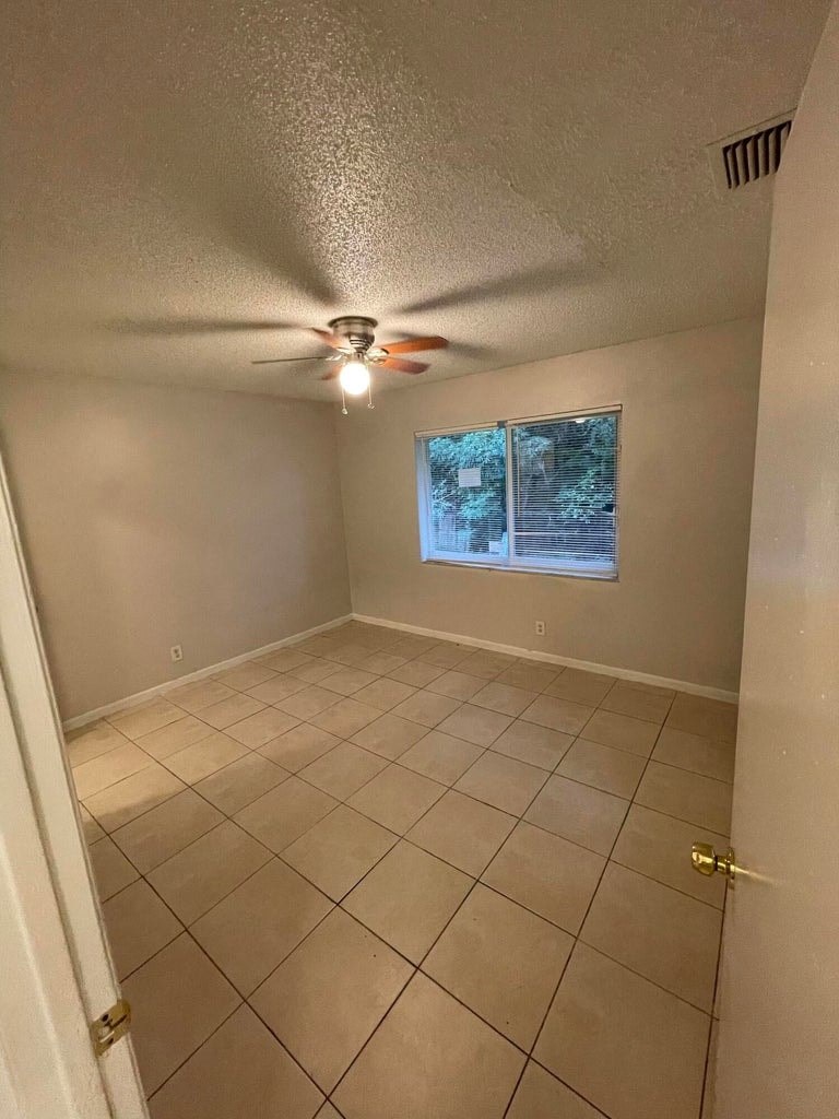 A room with a ceiling fan and a window.