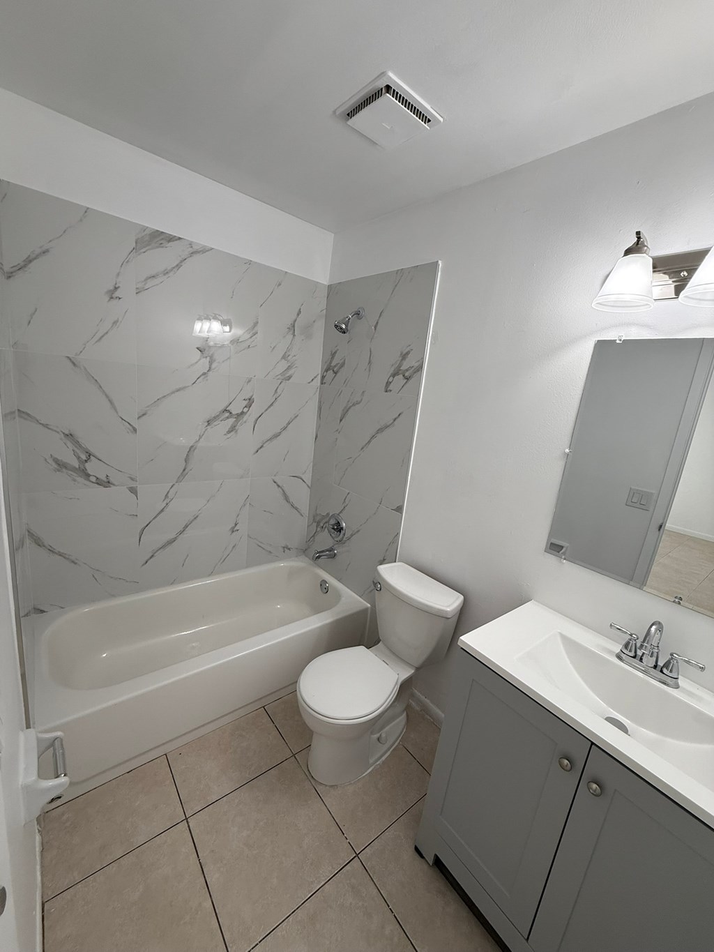 A white toilet sits next to a bathtub in a bathroom.