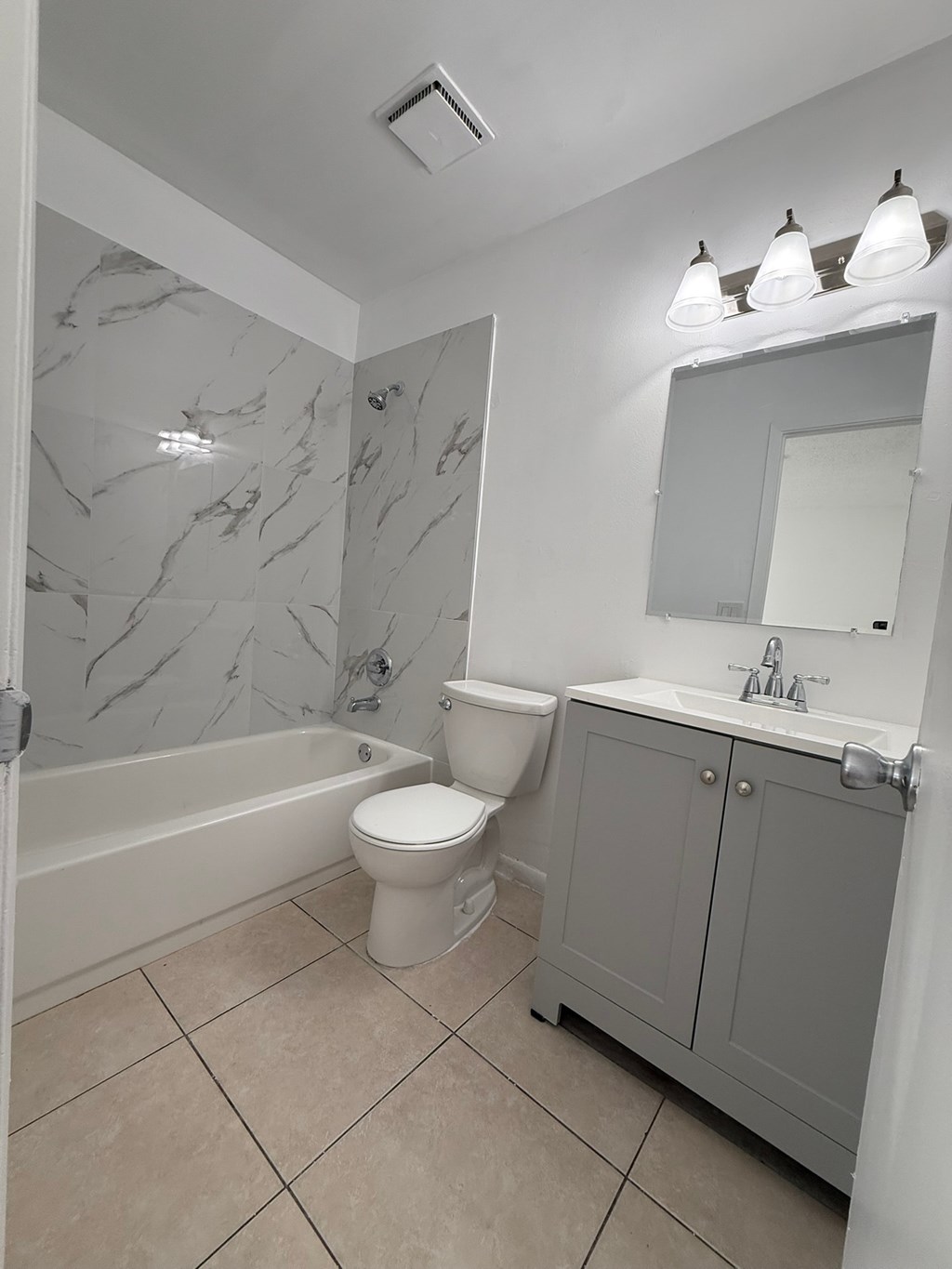 A white toilet sits next to a bathtub in a bathroom.