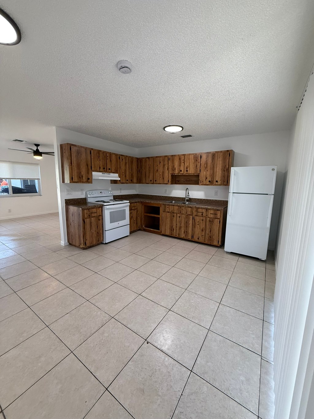 A kitchen with white appliances and wooden cabinets.