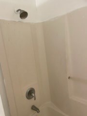 A white bathtub with a silver faucet and shower head.