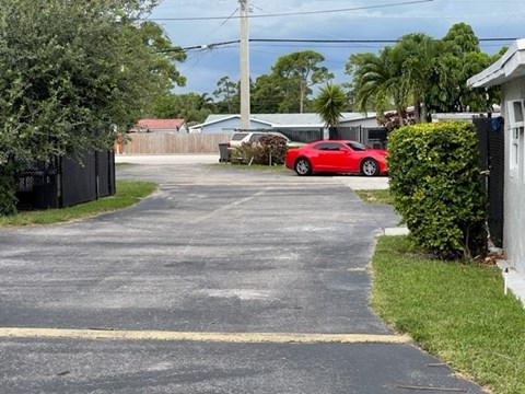 A red car is parked in a driveway.