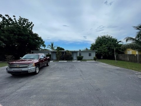 A red truck is parked in a driveway.