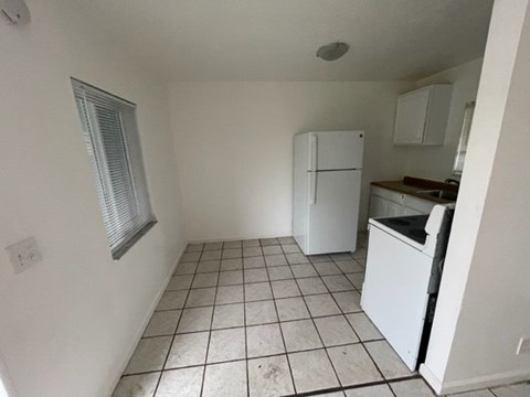 A kitchen with a white fridge and a white dishwasher.