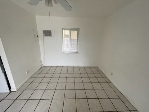 A room with a fan and a window.