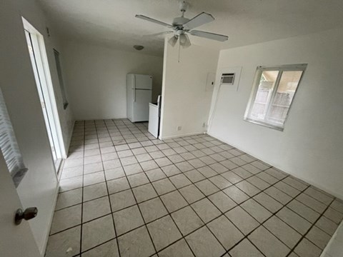 A room with a ceiling fan and tile flooring.