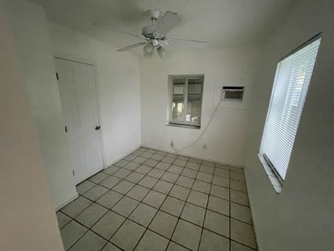 A room with a ceiling fan and tiled floor.