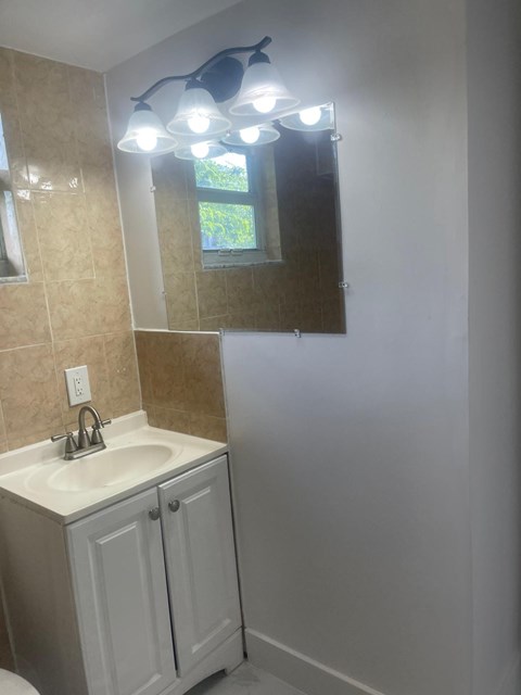 A bathroom with a sink and a mirror.