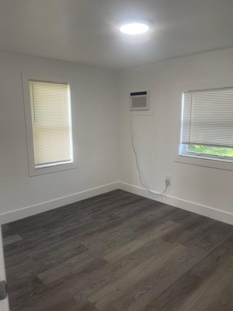 A room with a window and a wall socket.