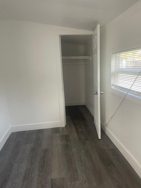 A room with a white door and a grey floor.