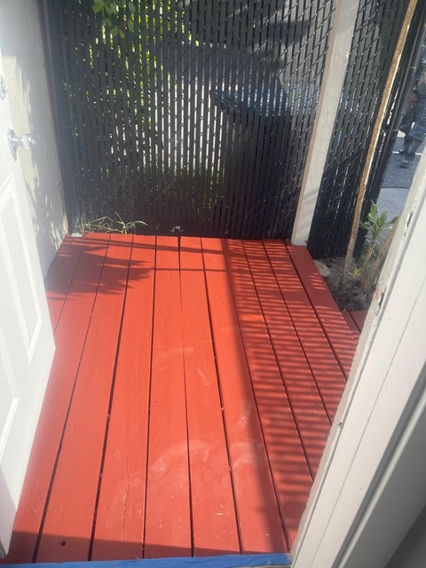 A red wooden deck is seen from the doorway.