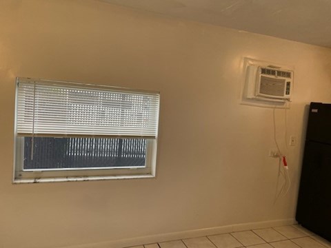 A window with blinds and an air conditioner on the wall.