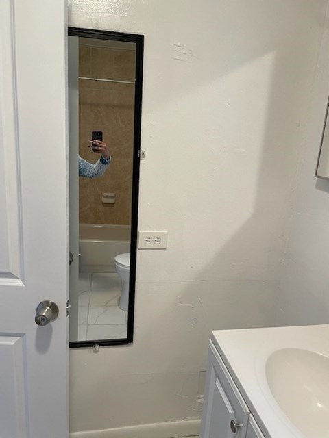 A person is taking a selfie in a bathroom mirror.
