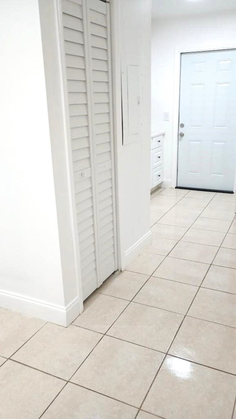 A white door is in a white hallway.