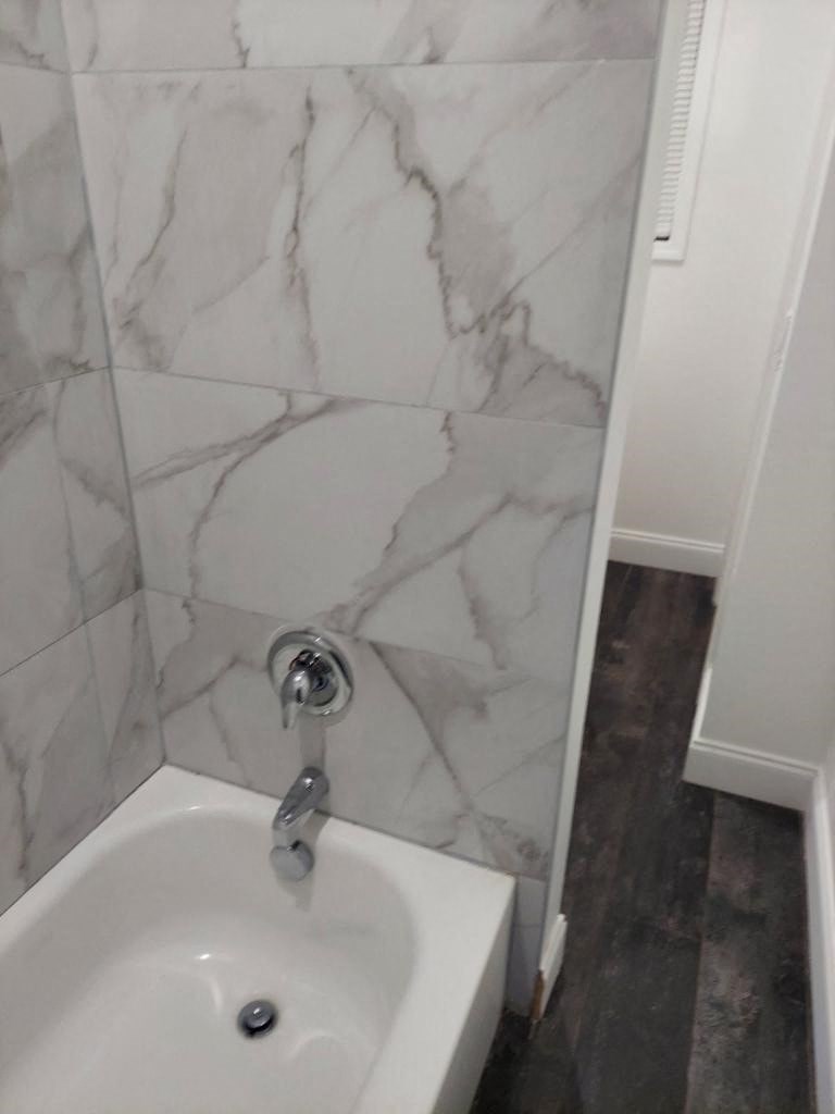a white bathroom with a sink and marble walls