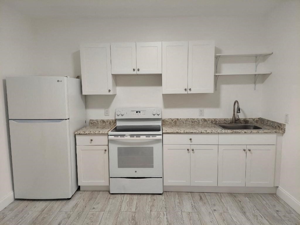 a kitchen with white appliances and white cabinets