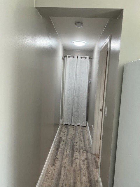 a long hallway with a door and a curtain