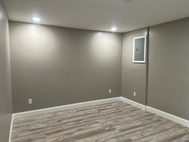 a empty room with a gray wall and wood floors