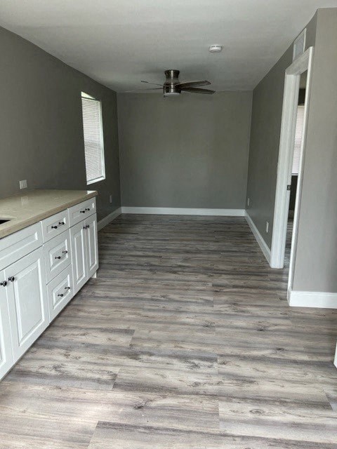 a kitchen with white cabinets and a ceiling fan