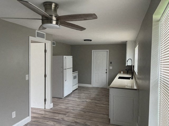 a kitchen with a white refrigerator and a ceiling fan