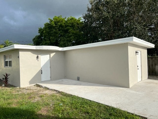 a small white building with a driveway and a garage door