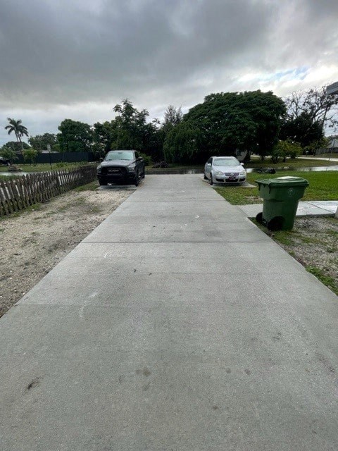 two cars parked at the end of a paved driveway