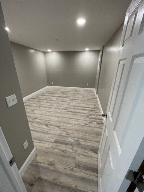 a hallway with a wood floor and white walls