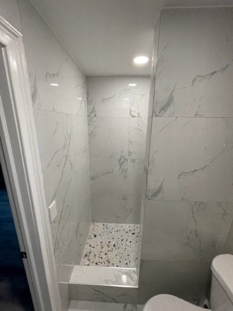 a white bathroom with a shower and a toilet