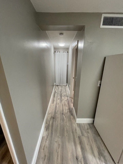 a hallway with wooden floors and a door
