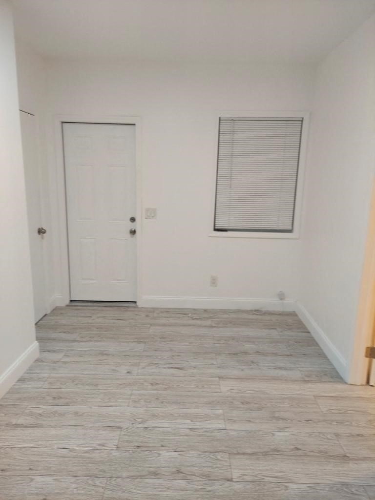 an empty room with a white door and a window
