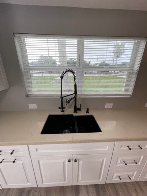 A kitchen with white cabinets and a black sink.