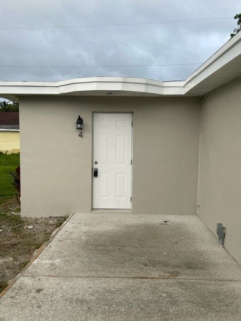 a white door on the side of a building with a sidewalk