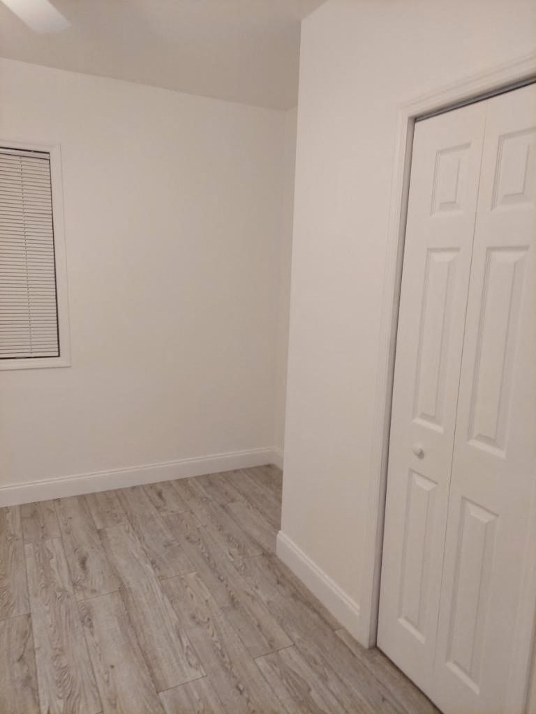 an empty room with white walls and a door
