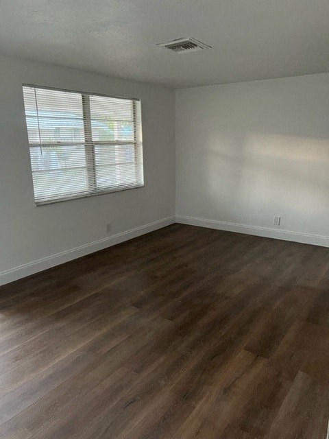 an empty room with a wooden floor and a window