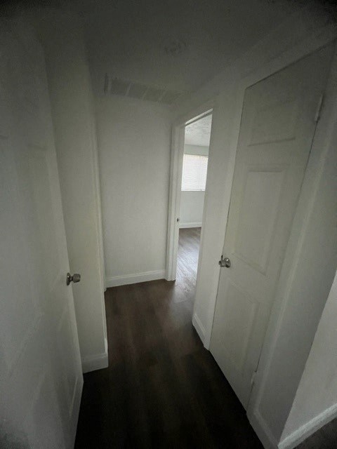 a hallway with a white door and a wooden floor