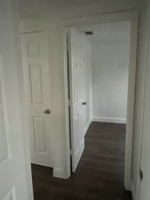 a hallway with a white door and a wood floor