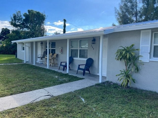 a white house with a lawn and chairs in front of it